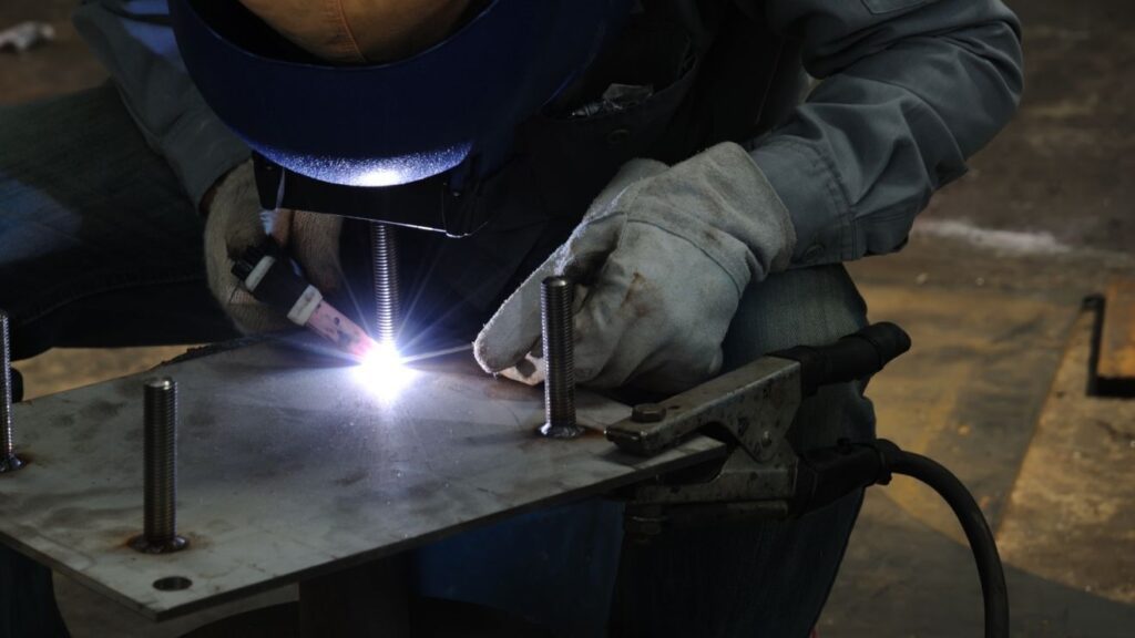 an engineer tig welding a small metal plate